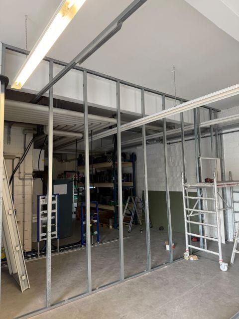 Neue Wände aus senkrechten Metallprofilen teilen die Halle, daneben ein Rollgerüst
