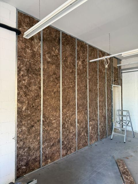 Braune Dämmung zwischen den senkrechten Metallständern einer neuen Wand